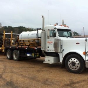 Large Welter Inc truck hauling a trailer with equipment